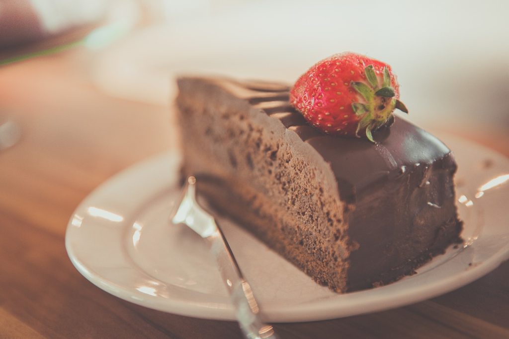 Part de fondant au chocolat avec une fraise sur le dessus en décoration.