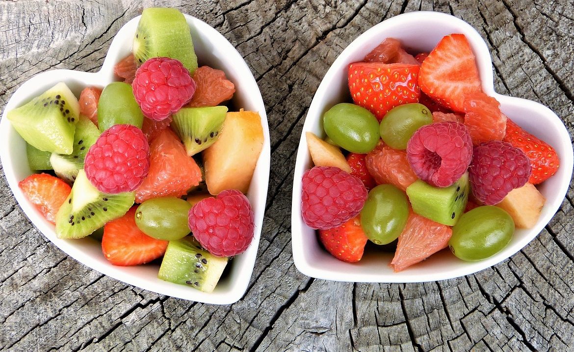 Deux bols de salade de fruits en forme de cœur.