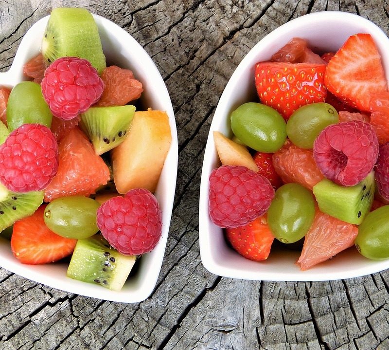 Deux bols de salade de fruits en forme de cœur.